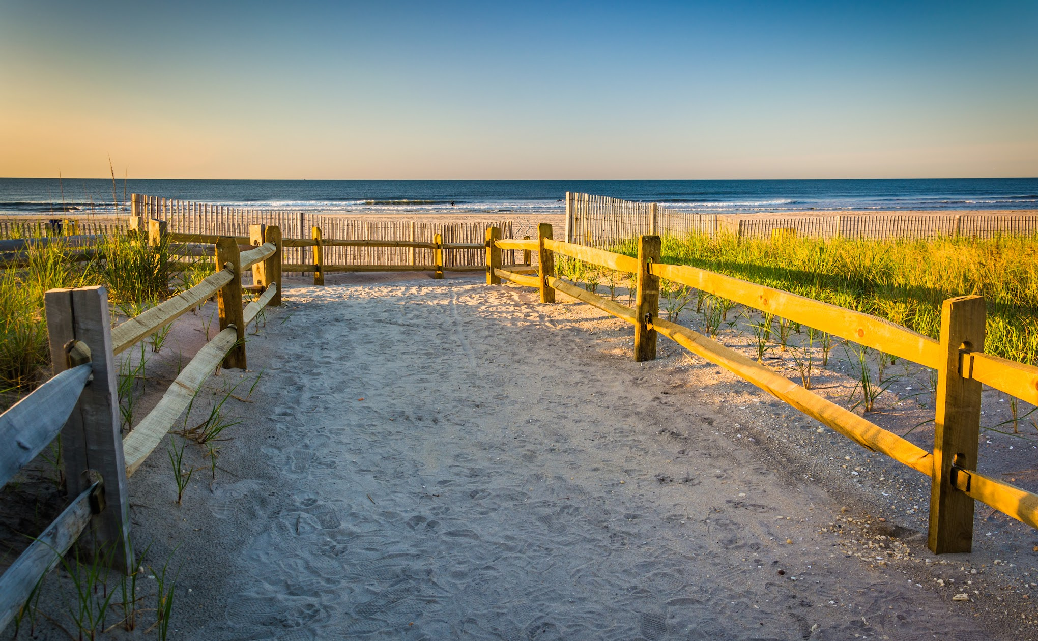 Sandy path through dune grass leading to the beach at the Jersey Shore.