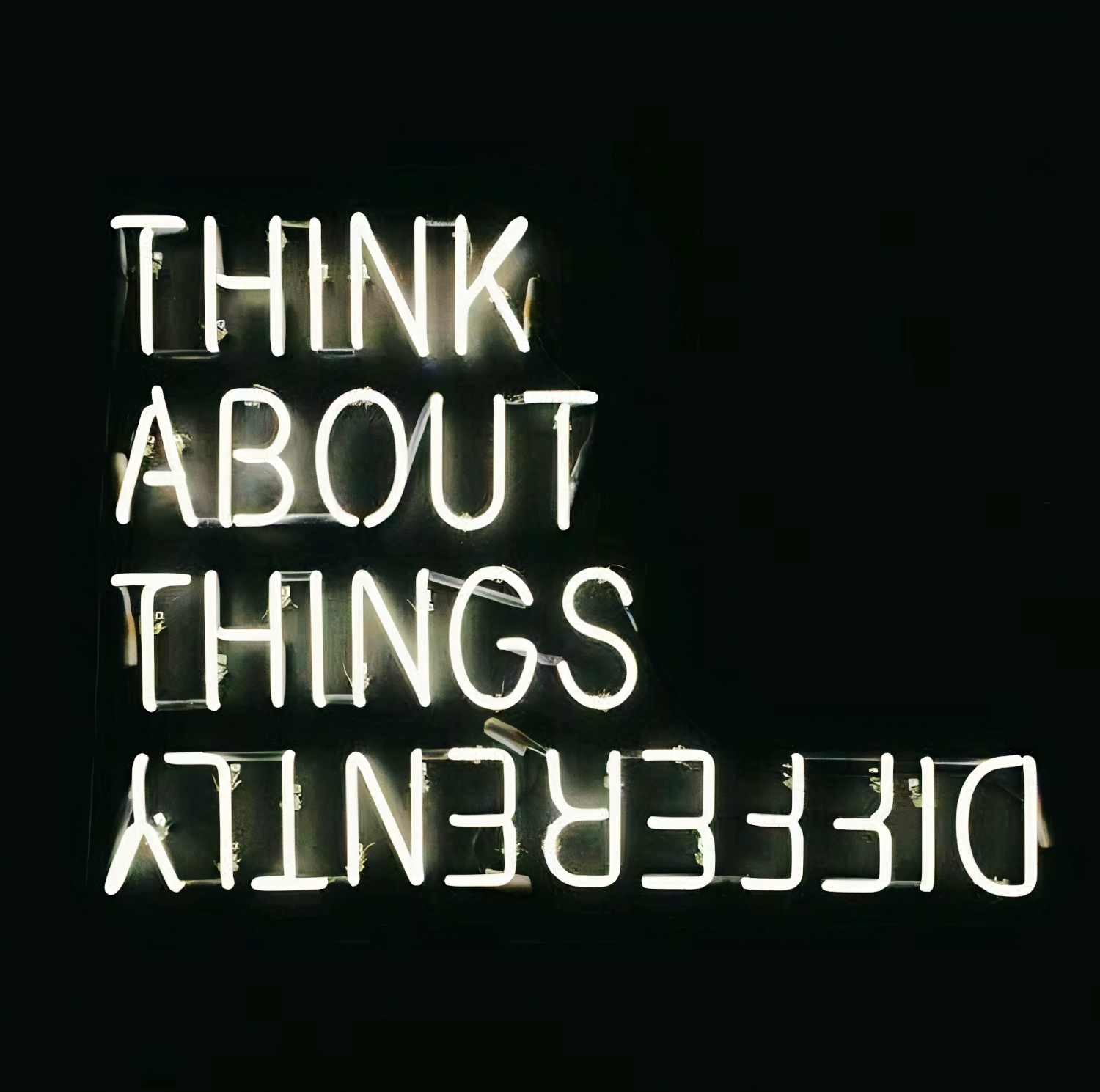 Neon sign reading “Think about things differently” glowing in the dark