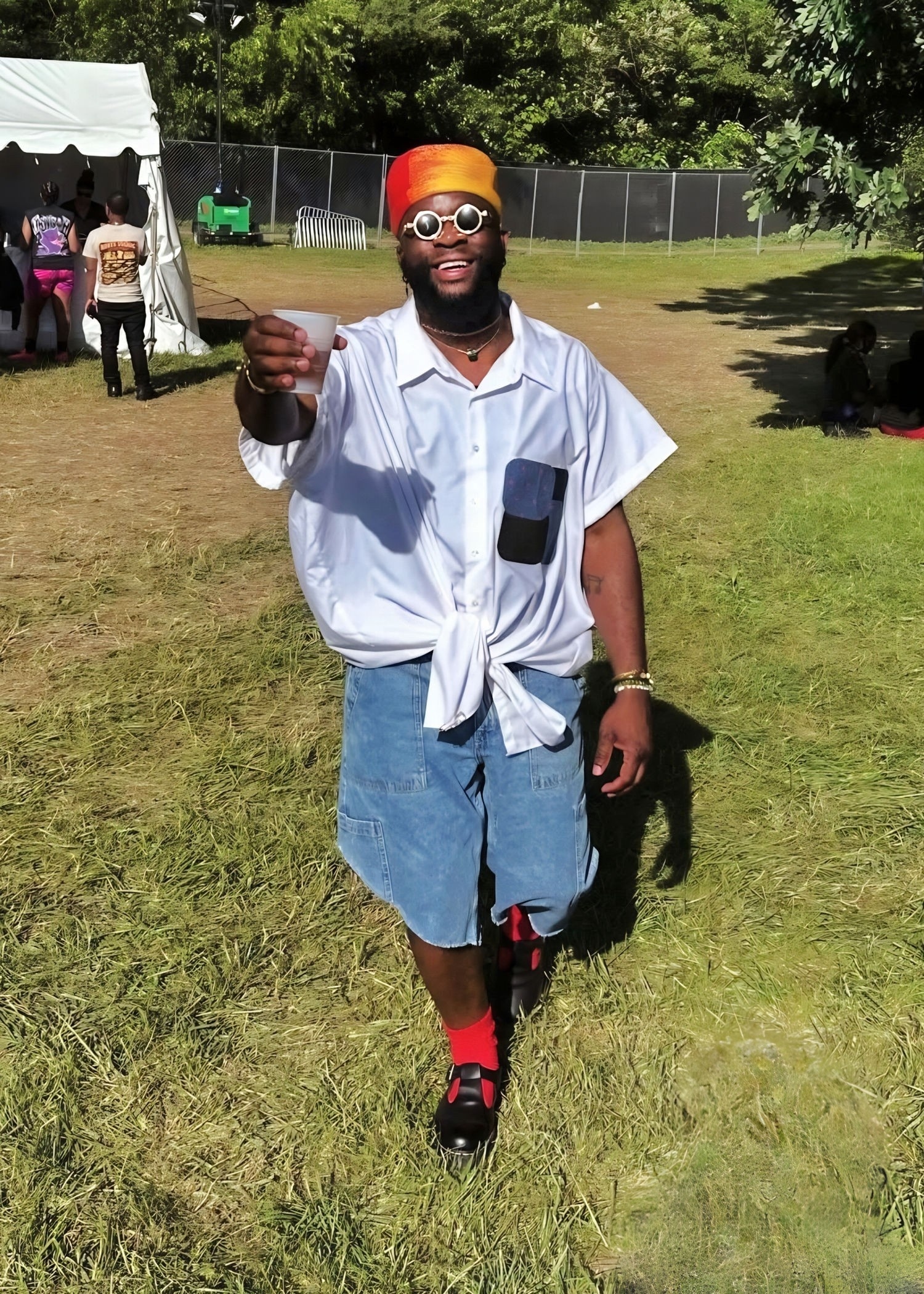 Roots Picnic fashion featuring a tied button-down shirt, colorful headwrap, round sunglasses, and relaxed festival workwear.