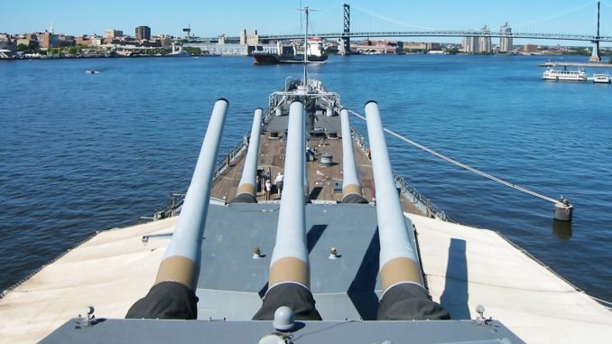 Battleship New Jersey’s 16-inch guns point toward the Delaware River and Ben Franklin Bridge.