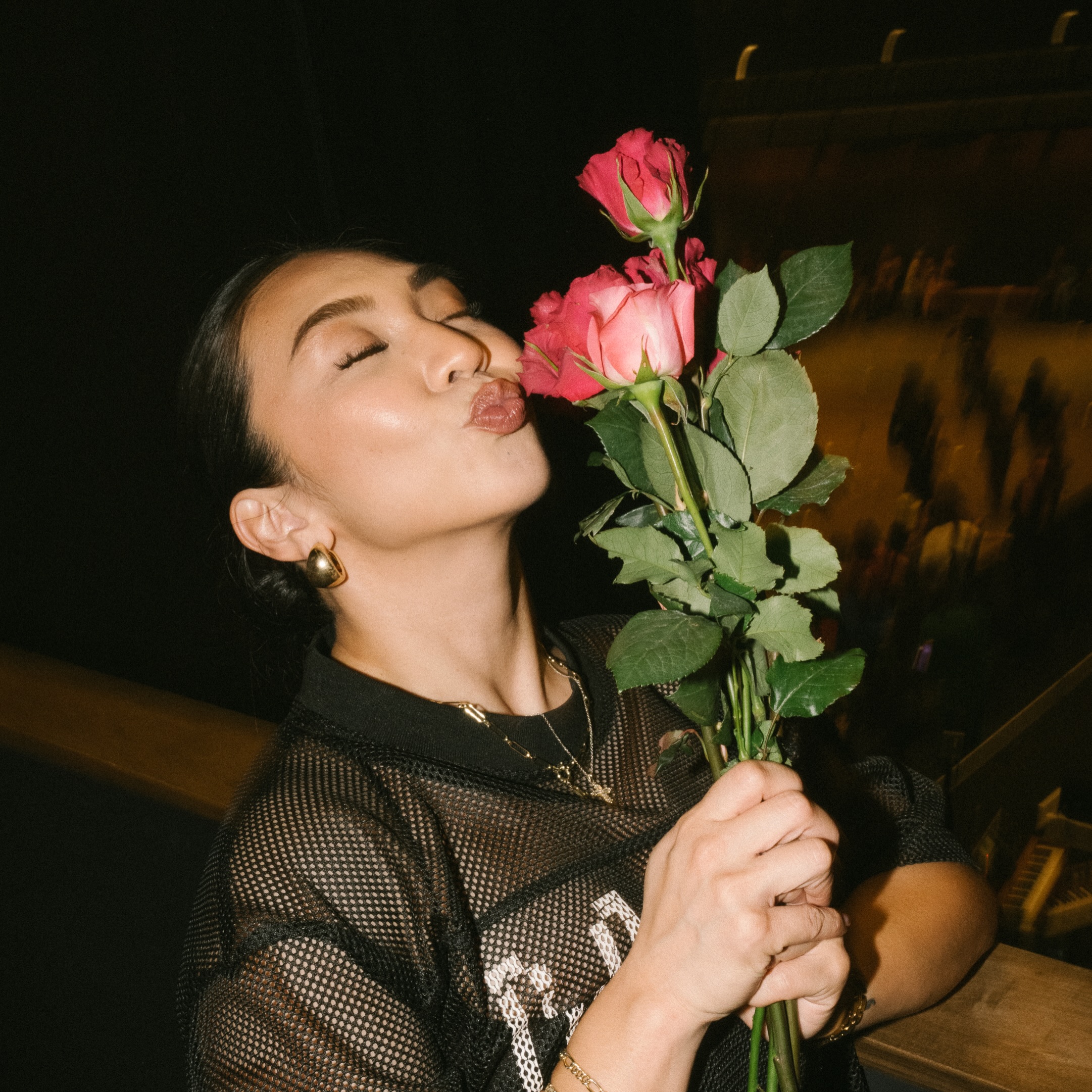 Sheryl Ann Padre smiles while holding pink roses after a performance
