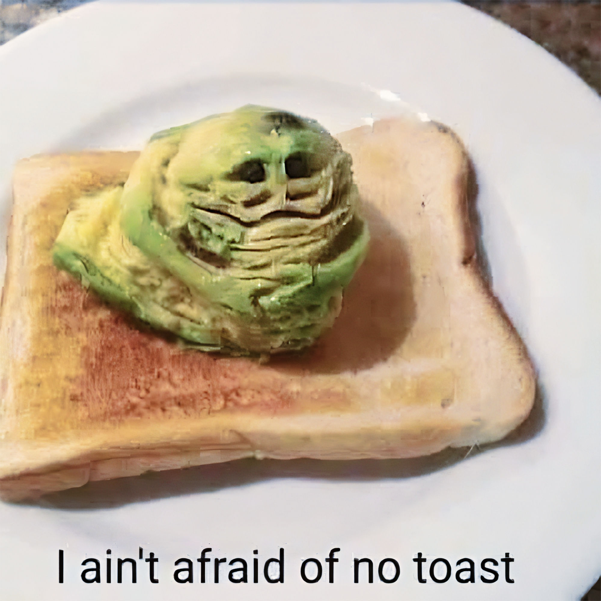 Toast topped with green avocado shaped like a ghost, with the text, “I ain’t afraid of no toast.”